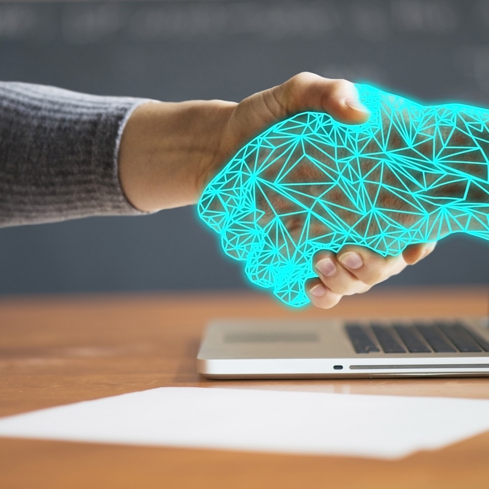 A human hand meeting a luminous digital hand